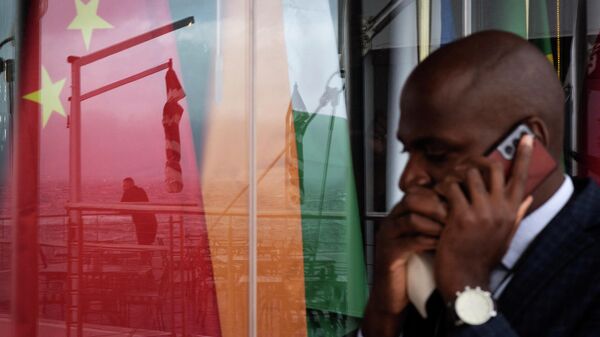 A man chats on a mobile phone as he walks past a reflection on a window of another man staring at the sea in front of the national flags of the BRICS (China, India, Russia, South Africa, Brazil) countries during the BRICS Foreign Ministers Meeting in Cape Town, on June 02, 2023. - Sputnik India