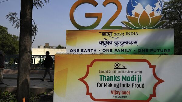 A commuter walks past a G20 logo at a crossing in New Delhi, India, Tuesday, Feb. 28, 2023. - Sputnik India