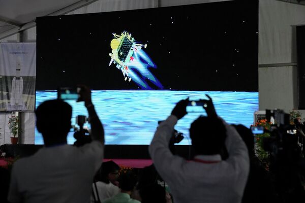 भारत के बंगलौर में चंद्रमा पर चंद्रयान-3 अंतरिक्ष यान की लैंडिंग का सीधा प्रसारण करते पत्रकार (AP Photo/Aijaz Rahi) - Sputnik भारत