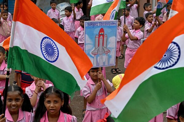 मुंबई में चंद्रयान-3 अंतरिक्ष यान के समर्थन में एकत्रित होकर भारतीय राष्ट्रीय ध्वज लहराते हुए छात्र (Photo by Indranil MUKHERJEE / AFP) - Sputnik भारत