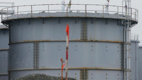 This file photo taken on November 12, 2014 shows workers wearing protective gear standing on a water tank that stores radiation contaminated water at the Fukushima Dai-ichi nuclear power plant in Okuma, Fukushima Prefecture.  - Sputnik भारत