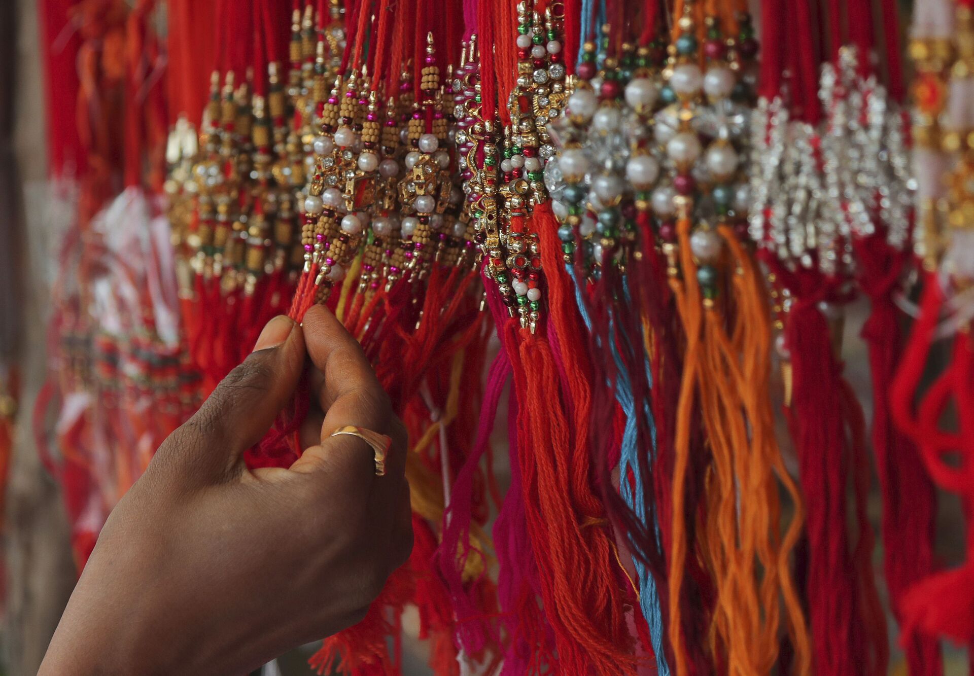 A woman shops for 'rakhi', or a sacred thread, ahead of 'Raksha Bandhan' festival in Hyderabad, India, Friday, July 31, 2020. - Sputnik भारत, 1920, 31.08.2023