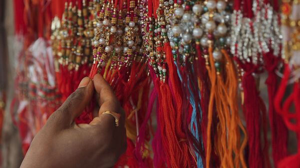 A woman shops for 'rakhi', or a sacred thread, ahead of 'Raksha Bandhan' festival in Hyderabad, India, Friday, July 31, 2020. - Sputnik India
