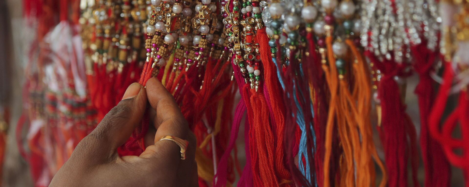 A woman shops for 'rakhi', or a sacred thread, ahead of 'Raksha Bandhan' festival in Hyderabad, India, Friday, July 31, 2020. - Sputnik India, 1920, 31.08.2023