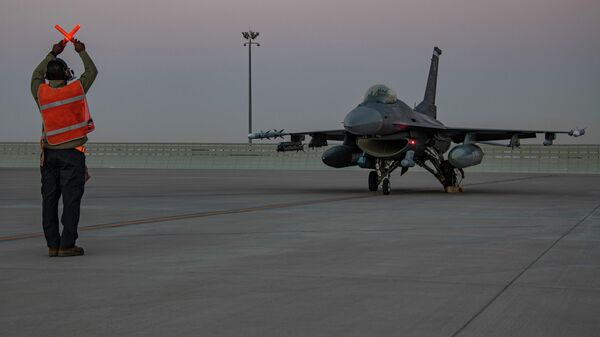 In this handout photo from the U.S. Air Force, an airman guides an F-16 Fighting Falcon during training at Al-Udeid Air Base, Qatar in January 2022. File photo. - Sputnik भारत