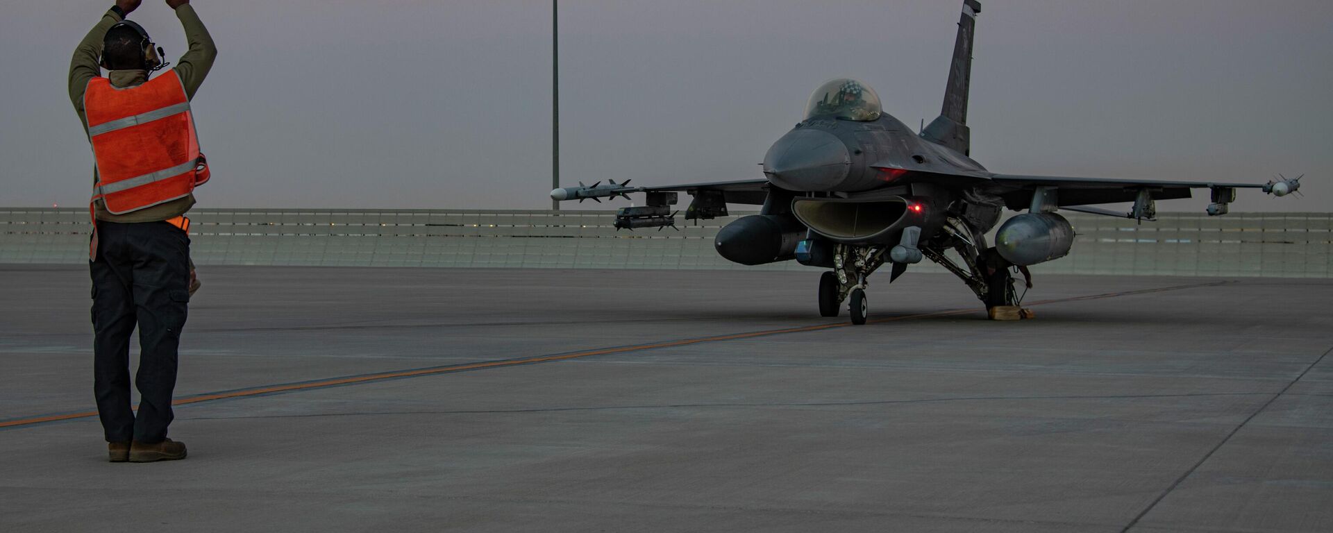 In this handout photo from the U.S. Air Force, an airman guides an F-16 Fighting Falcon during training at Al-Udeid Air Base, Qatar in January 2022. File photo. - Sputnik भारत, 1920, 26.08.2023