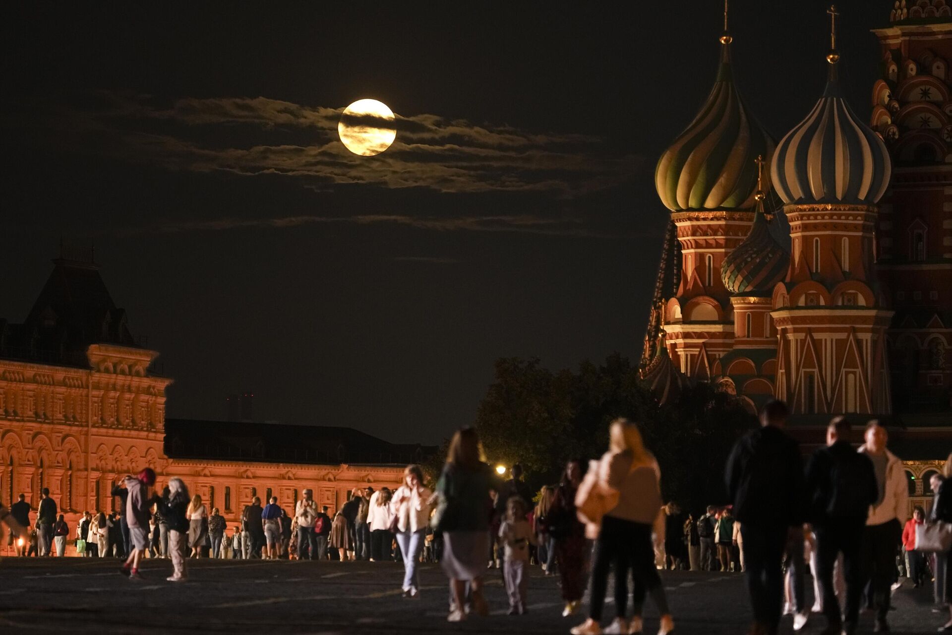 The August Super Blue Moon sets behind a historical building and the St. Basil's Cathedral, right, as people walk in Red Square in Moscow, Russia, Wednesday, Aug. 30, 2023 - Sputnik भारत, 1920, 03.09.2023