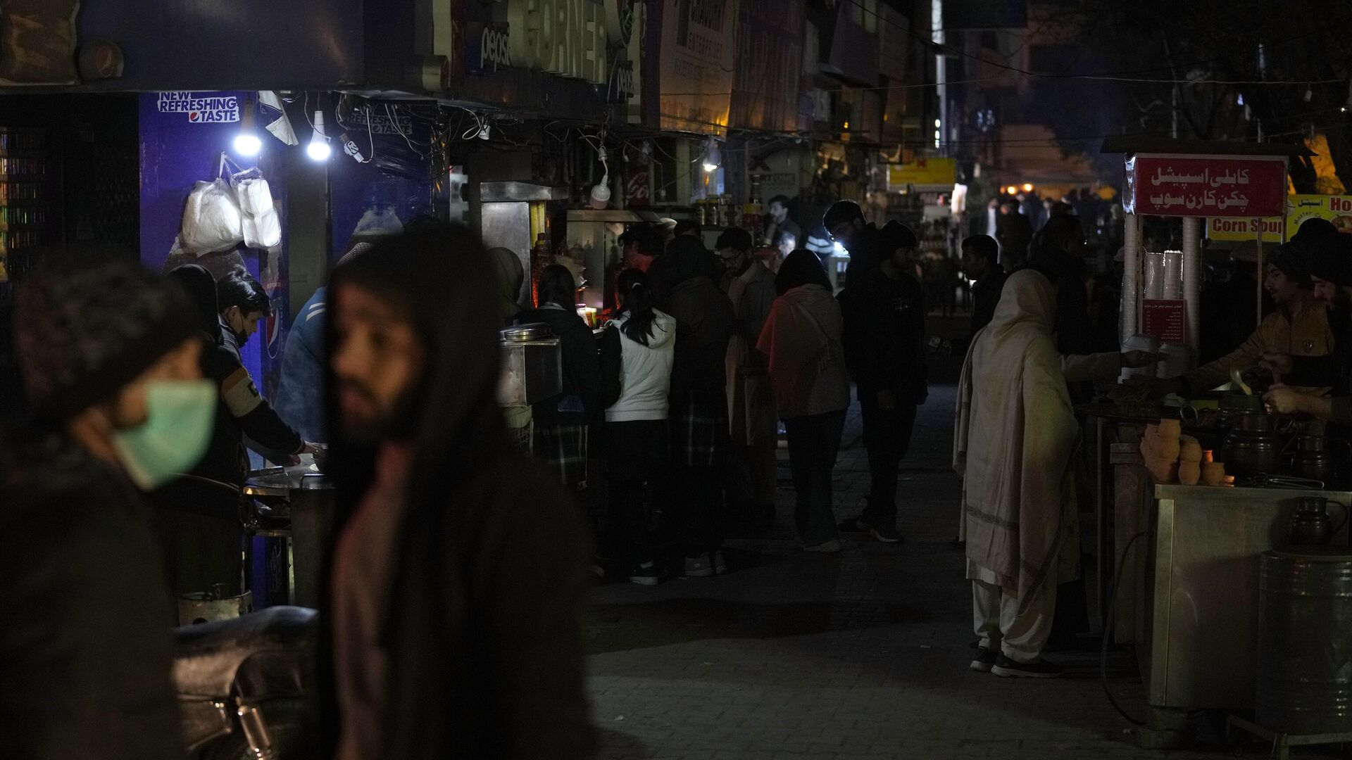 People visit a market, where some shopkeeper are using generators for electricity during a national-wide power breakdown, in Islamabad, Pakistan, Monday, Jan. 23, 2023. - Sputnik India, 1920, 05.09.2023