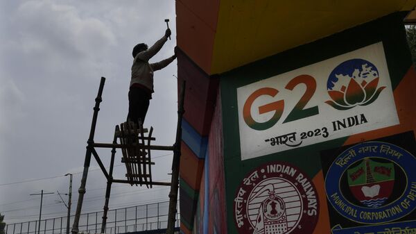 A worker paints an under-construction overhead bridge near the main venue of the G20 Summit, in New Delhi, India, Thursday, Aug. 24, 2023. - Sputnik भारत