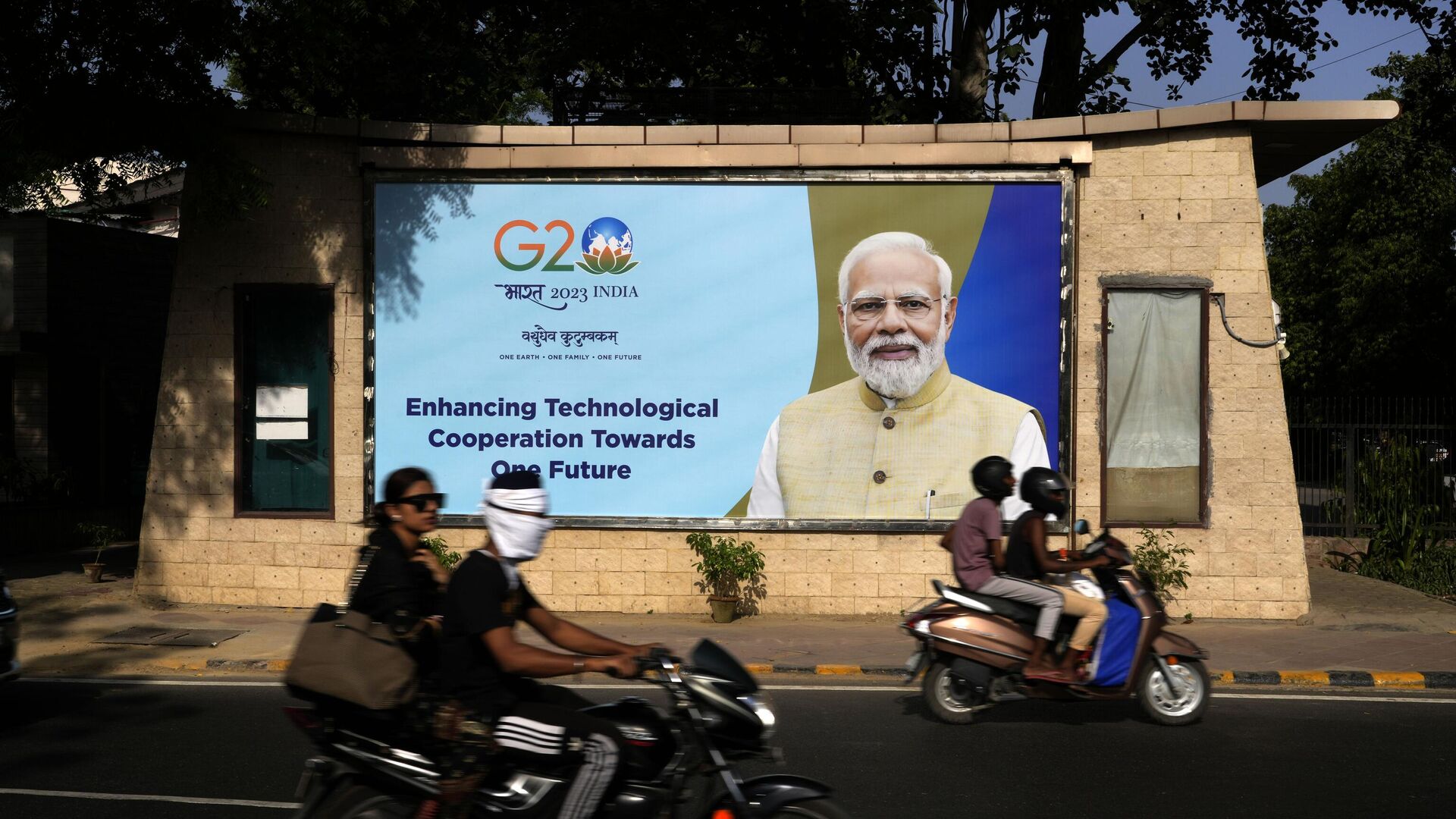 Motorcyclists drive past a billboard featuring Indian Prime Minister Narendra Modi ahead of this week's summit of the Group of 20 nations in New Delhi, India, Monday, Sept. 4, 2023. - Sputnik भारत, 1920, 08.09.2023