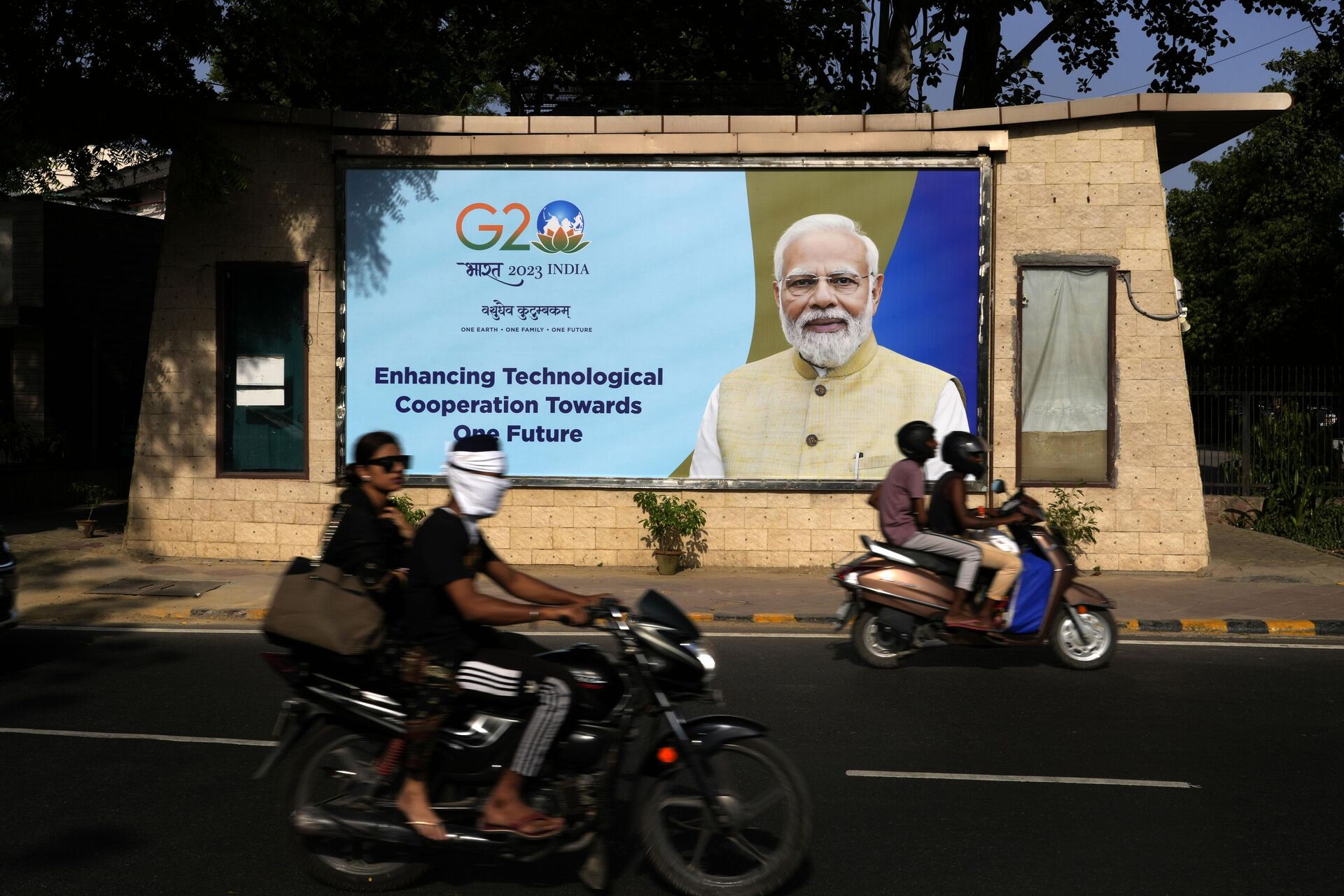 Motorcyclists drive past a billboard featuring Indian Prime Minister Narendra Modi ahead of this week's summit of the Group of 20 nations in New Delhi, India, Monday, Sept. 4, 2023. - Sputnik India, 1920, 07.09.2023
