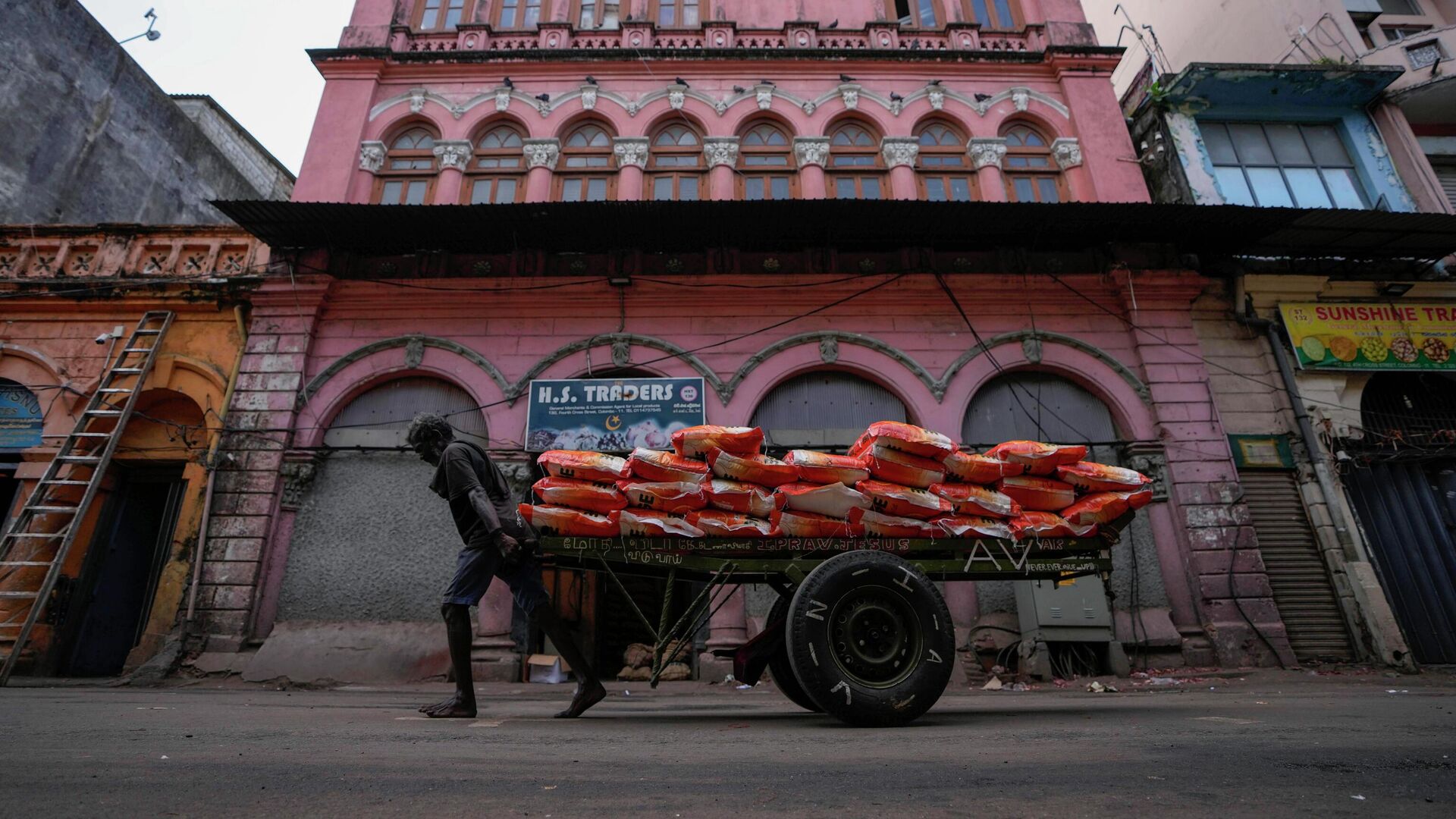 A laborer pulls a cart load of imported rice at a wholesale market in Colombo, Sri Lanka, Sunday, June 26, 2022. - Sputnik India, 1920, 10.09.2023