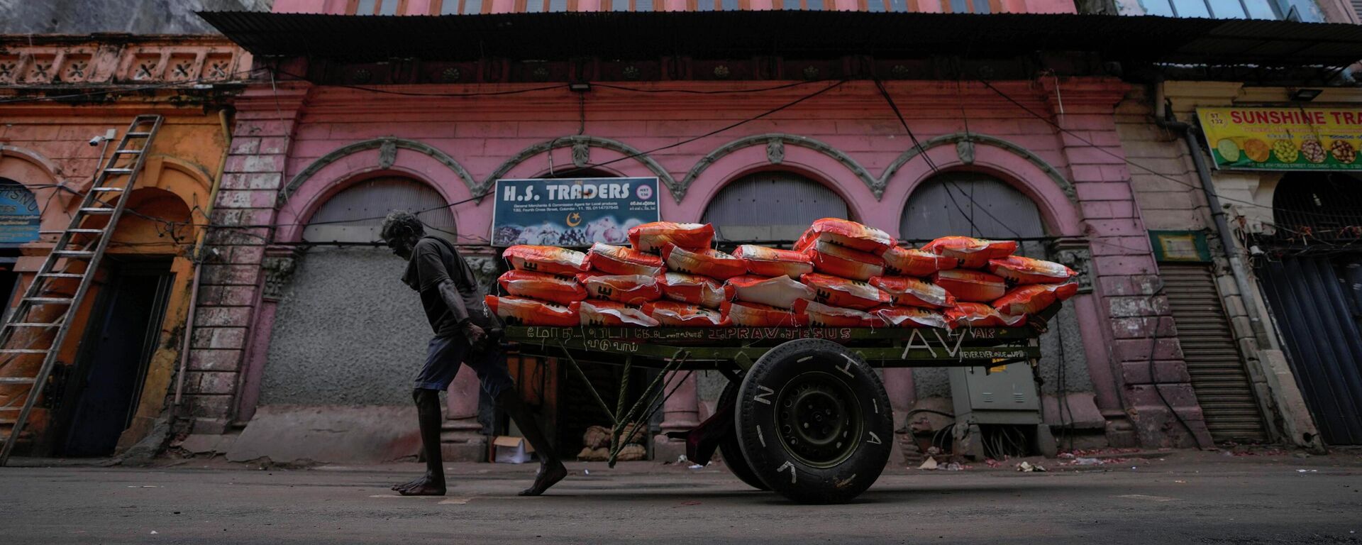 A laborer pulls a cart load of imported rice at a wholesale market in Colombo, Sri Lanka, Sunday, June 26, 2022. - Sputnik India, 1920, 10.09.2023