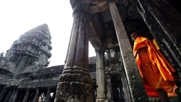 In this photo taken Friday, July 16, 2010, a monk strolls through Angkor Wat in Siem Reap province, about 143 miles (230 kilometers) northwest of Phnom Penh, Cambodia - Sputnik India