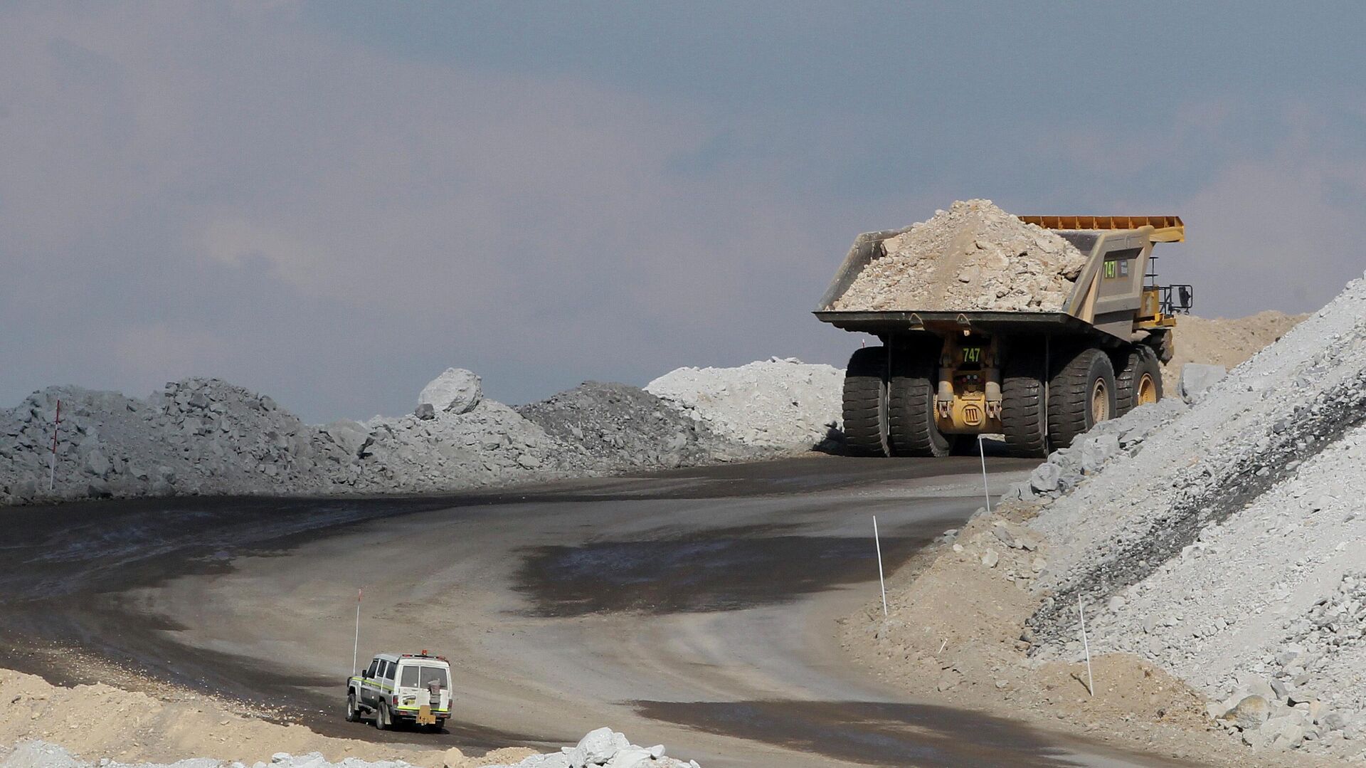 In this Sept. 11, 2012, file photo, a four-wheel-drive vehicle follows a large mining truck as it makes its way to the top of a Boggabri coal mine near Gunnedah, Australia, 450 kilometers (280 miles) northwest of Sydney.  - Sputnik भारत, 1920, 08.09.2023