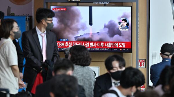 People watch a television screen showing a news broadcast with file footage of a North Korean missile test, at a railway station in Seoul on May 7, 2022, after North Korea fired a submarine-launched ballistic missile according to South Korea's military. - Sputnik भारत