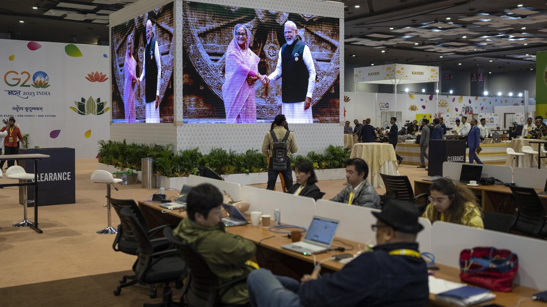 Journalists work at the international media centre as live pictures displayed on a big screen show Indian Prime Minister Narendra Modi welcomes Bangladesh Prime Minister Sheikh Hasina at Bharat Mandapam convention center for the G20 Summit in New Delhi, India, Saturday, Sept., 9, 2023.  - Sputnik भारत, 1920, 09.09.2023