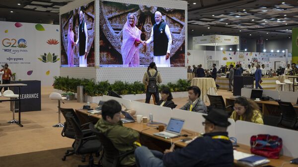 Journalists work at the international media centre as live pictures displayed on a big screen show Indian Prime Minister Narendra Modi welcomes Bangladesh Prime Minister Sheikh Hasina at Bharat Mandapam convention center for the G20 Summit in New Delhi, India, Saturday, Sept., 9, 2023.  - Sputnik भारत