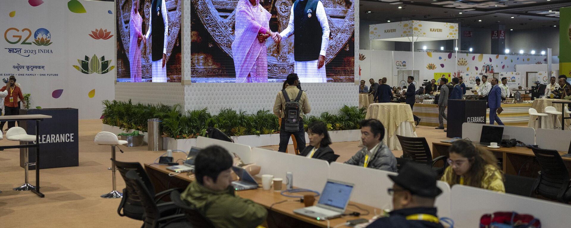Journalists work at the international media centre as live pictures displayed on a big screen show Indian Prime Minister Narendra Modi welcomes Bangladesh Prime Minister Sheikh Hasina at Bharat Mandapam convention center for the G20 Summit in New Delhi, India, Saturday, Sept., 9, 2023.  - Sputnik भारत, 1920, 09.09.2023