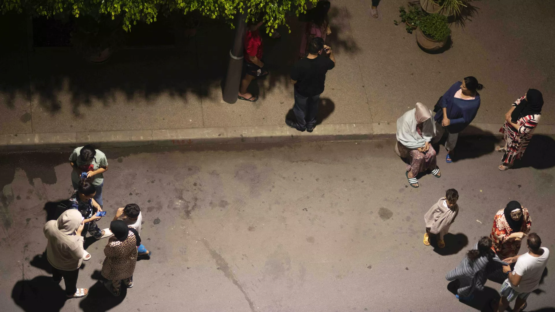 People take shelter and check for news on their mobile phones after an earthquake in Rabat, Morocco, Friday, Sept. 8, 2023. A powerful earthquake struck Morocco late Friday, damaging buildings in major cities and sending panicked people pouring into streets and alleyways from Rabat to Marrakech.