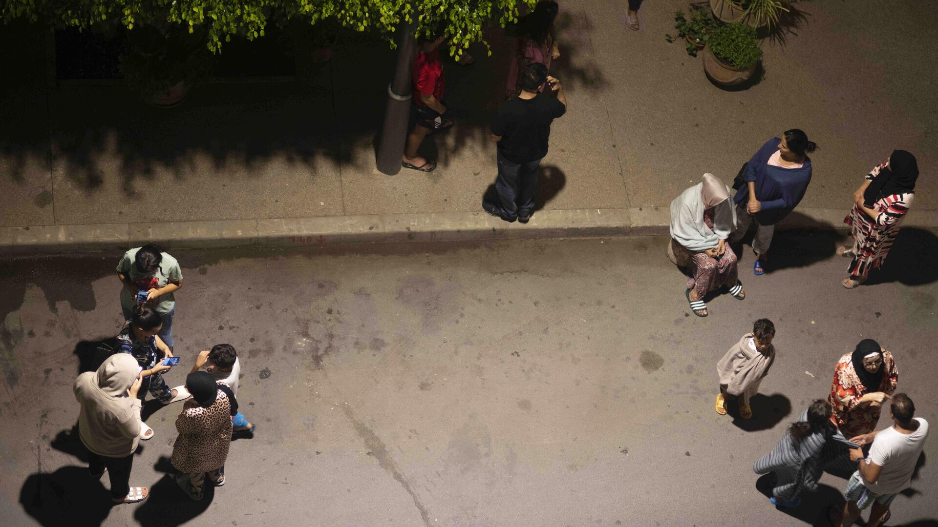People take shelter and check for news on their mobile phones after an earthquake in Rabat, Morocco, Friday, Sept. 8, 2023. A powerful earthquake struck Morocco late Friday, damaging buildings in major cities and sending panicked people pouring into streets and alleyways from Rabat to Marrakech. - Sputnik India, 1920, 09.09.2023