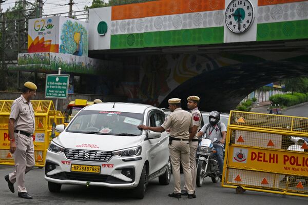 नई दिल्ली में G-20 नेताओं के शिखर सम्मेलन के दौरान पुलिस कर्मी सड़क पर यात्रियों के वाहनों की जांच कर रहे हैं। (Photo by Arun SANKAR / AFP) - Sputnik भारत