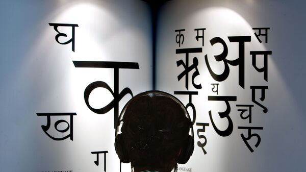 A woman listens to explanations on headphones about the Indian languages Hindi, left, and Marathi at the International Book Fair in Frankfurt, central Germany - Sputnik India