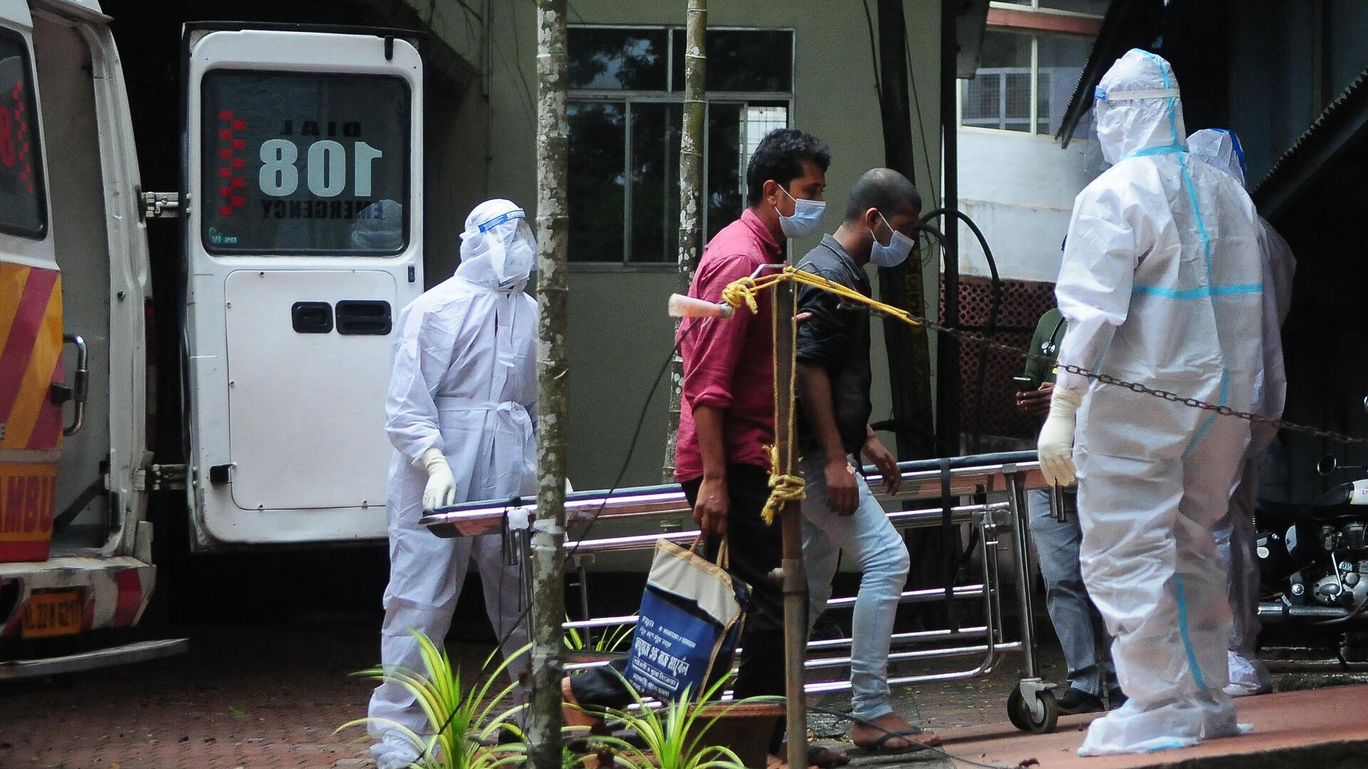 Health workers wearing protective gear shift people who have been in contact with a person infected with the Nipah virus to an isolation center at a goverment hospital in Kozikode, in India's Kerala state on September 14, 2023.  - Sputnik भारत, 1920, 14.09.2023