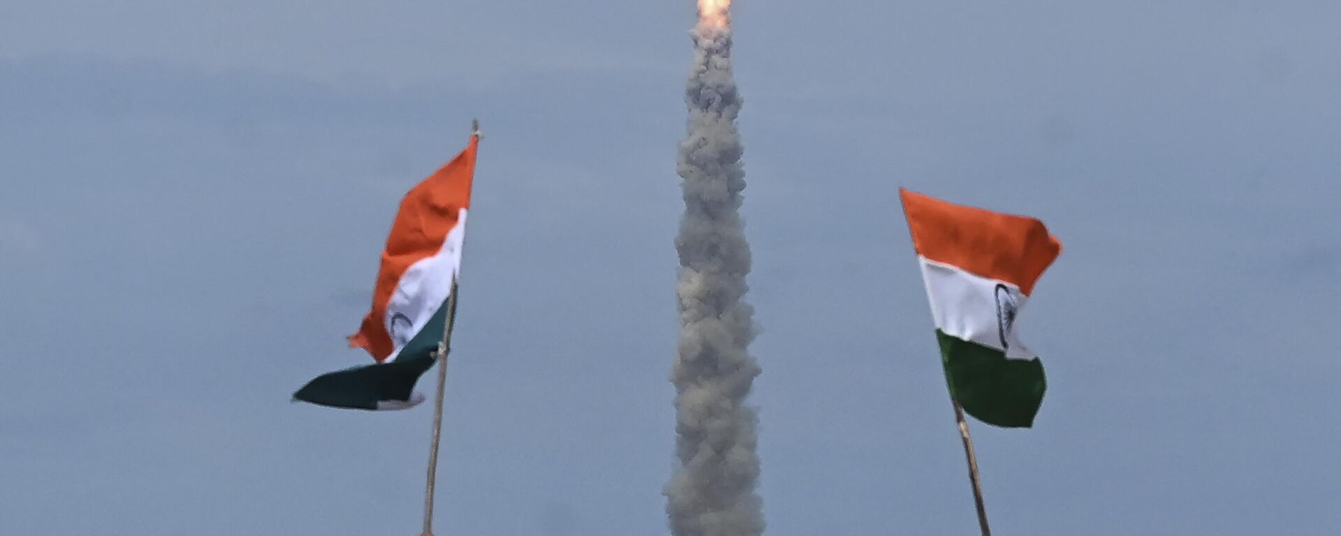 People wave Indian flags as an Indian Space Research Organisation (ISRO) rocket carrying the Chandrayaan-3 spacecraft lifts off from the Satish Dhawan Space Centre in Sriharikota, an island off the coast of southern Andhra Pradesh state on July 14, 2023.  - Sputnik भारत, 1920, 01.01.2024