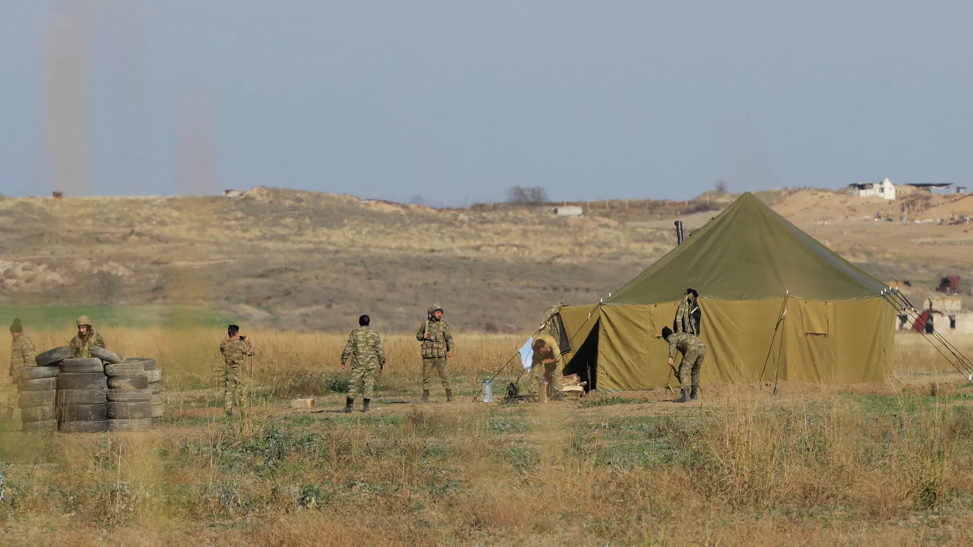 Azerbaijanian border gather at a tent as they control their side of the new border between the region of Nagorno-Karabakh and Azerbaijan, near the village of Berdashen, Tuesday, Nov. 24, 2020