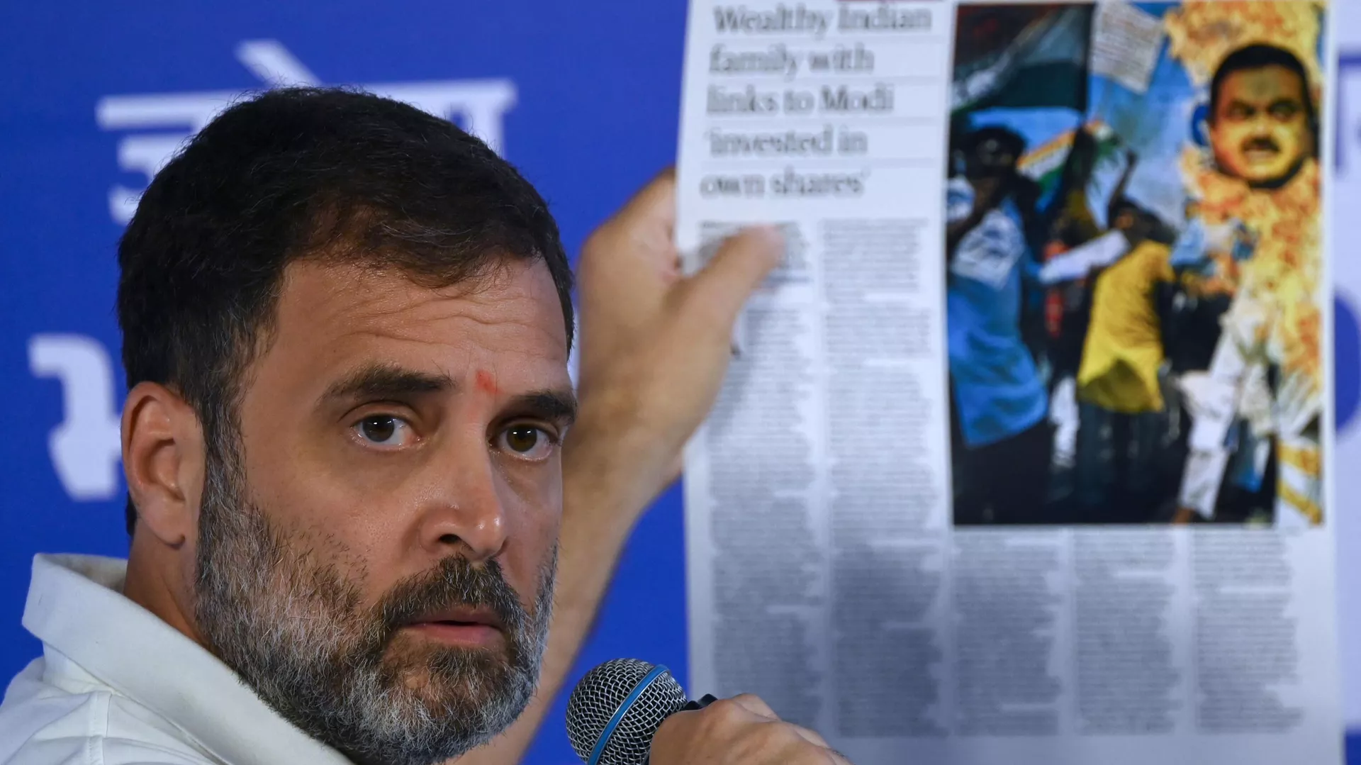 India's Congress party leader Rahul Gandhi holds a printout of news media report on industrialist Gautam Adani during a media briefing on the sidelines of the third meeting of the opposition INDIA Alliance in Mumbai on August 31, 2023.