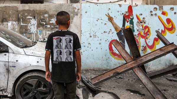 A boy looks a mural depicting historical Palestine coloured with the Palestinian flag riddled with bullet holes after a raid by Israeli forces in the Jenin camp for Palestinian refugees on September 20, 2023. The Palestinian health ministry announced the death of Yasser Mussa, a 29-year-old Palestinian who was wounded during an Israeli raid on the West Bank city of Jenin late on September 19.  - Sputnik भारत