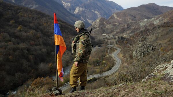 FILE - In this Wednesday, Nov. 25, 2020 file photo, An ethnic Armenian soldier stands guard next to Nagorno-Karabakh's flag atop of the hill near Charektar , Nov. 25, 2020 - Sputnik भारत