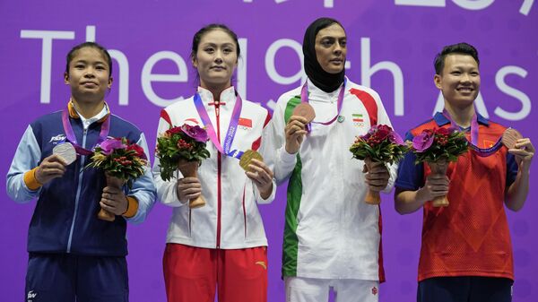 Gold medalist China's Xiaowei Wu, second left, poses with silver medalist India's Roshibina Devi Naorem, left, bronze medalists Vietnam's Thi Thu Thuy Nguyen and Iran's Shahrbano Mansouriyan Semiromi during the awards ceremony of the Wushu women's 60kg at 19th Asian Games in Hangzhou, China, Thursday, Sept. 28, 2023. - Sputnik भारत