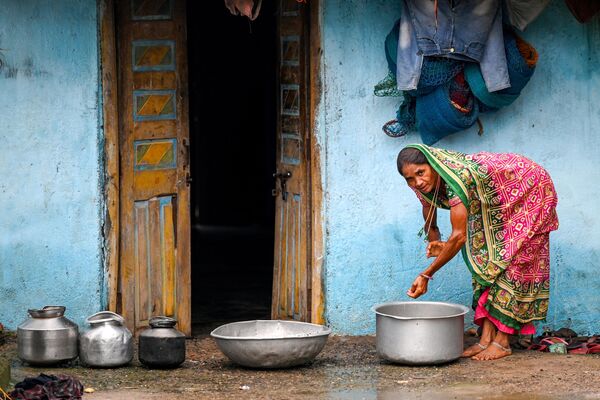 गुजरात के टंकरी बंदर गांव में एक महिला अपने घर में काम कर रही हैं। - Sputnik भारत