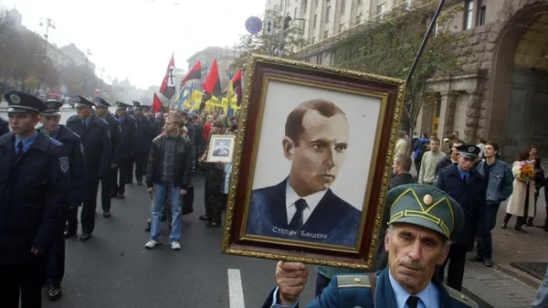A partisan veteran from the Ukrainian Insurgent Army carries a portrait of Ukrainian Insurgent Army leader Stepan Bandera during a march in Kiev. Ukraine, Saturday, Oct. 15, 2005. The supporters of the Red Army veterans were rallying to protest against calls by Ukrainian partisans to receive official recognition as World War II veterans. The partisans from the Ukrainian Insurgent Army fought against both Nazis and Red Army soldiers during World War II in a bid to create an independent Ukraine. - Sputnik भारत