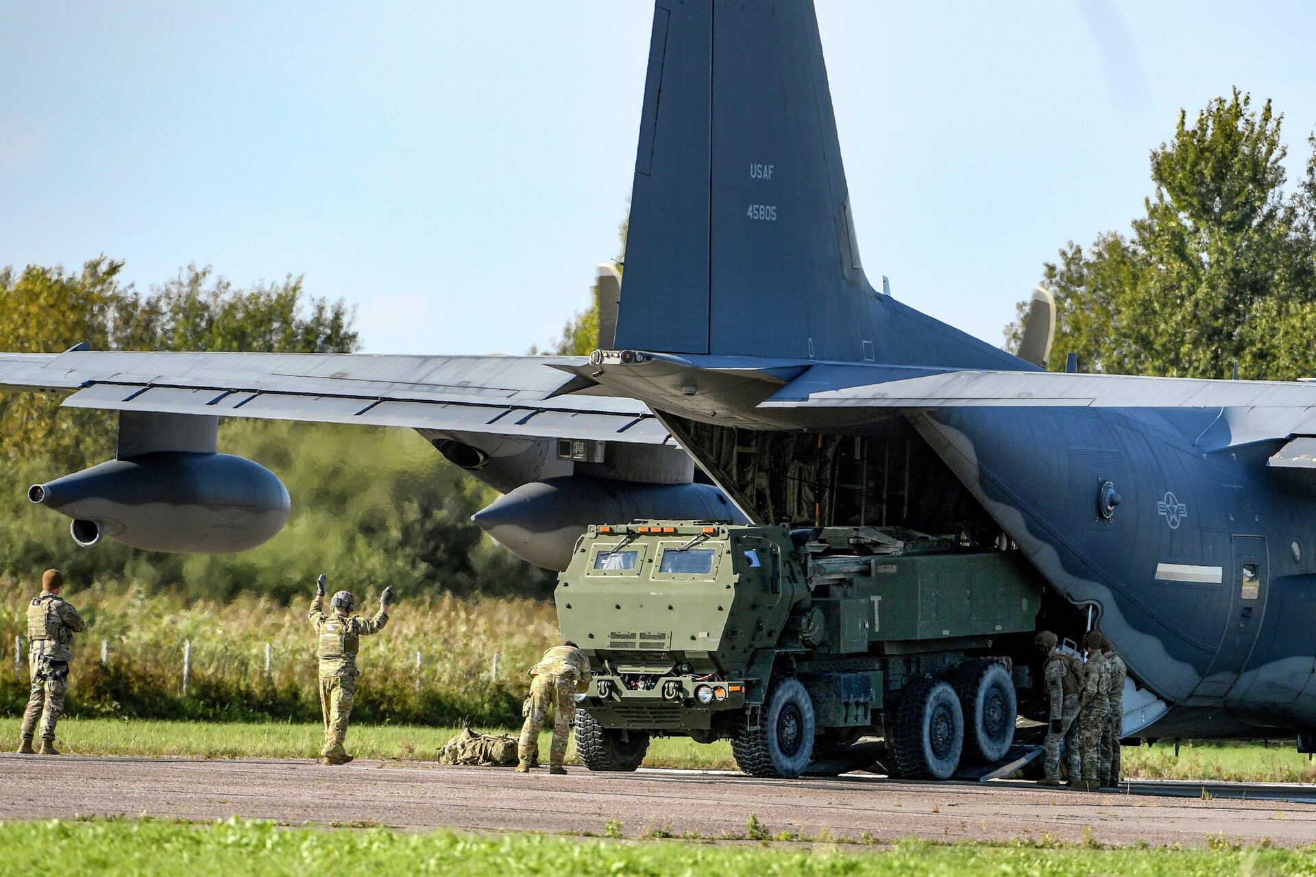 Soldiers load a High-Mobility Artillery Rocket System (HIMARS ) from a US Special Operations MC-130J aircraft during military exercises at Spilve Airport in Riga, Latvia, on Sept. 26, 2022. - Sputnik India, 1920, 09.10.2023