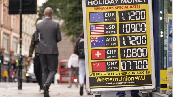 People walk past a bureau de change which displays the currency conversion rates, in London, Wednesday, Oct. 12, 2022. The pound sank against the dollar early Wednesday after the Bank of England governor confirmed the bank won't extend an emergency debt-buying plan introduced last month to stabilize financial markets. - Sputnik भारत