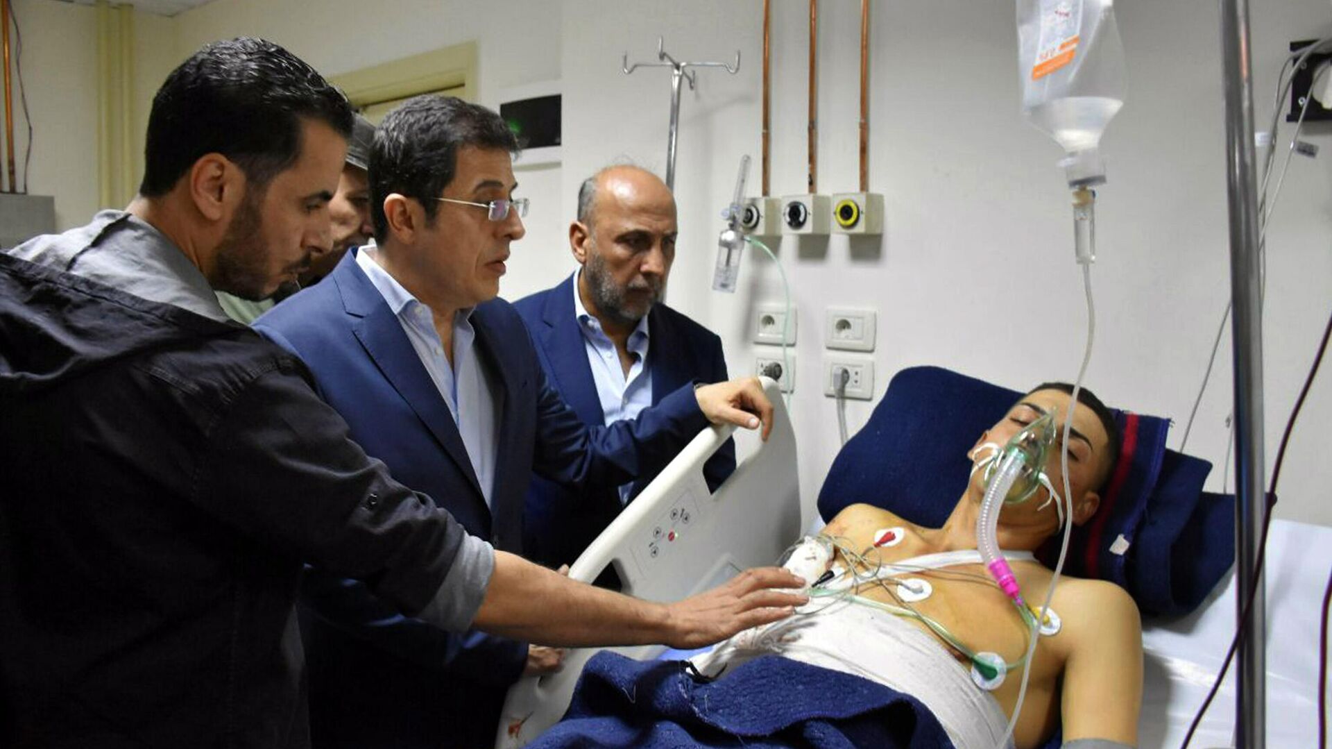 This photo released by the Syrian official news agency SANA shows Syrian Health Minister Hassan al-Ghabash, center, checking a man injured in a drone attack that hit a military graduation ceremony in Homs, Syria, Thursday, Oct. 5, 2023. Syria's health minister has raised the casualty tolls from a drone attack that hit a packed military graduation ceremony to 80 killed and 240 wounded. It was one of the deadliest attacks on the Syrian army recently, with its conflict now in its thirteenth year. - Sputnik भारत, 1920, 06.10.2023