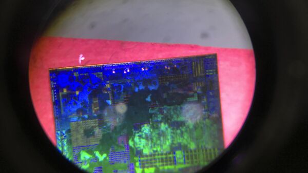 FILE - A Chinese microchip is seen through a microscope set up at the booth for the state-controlled Tsinghua Unigroup project which is aimed at driving China's semiconductor ambitions during the 21st China Beijing International High-tech Expo in Beijing, China, on May 17, 2018. China has imposed export curbs on two metals used in computer chips and solar cells, expanding a squabble with Washington over high-tech trade ahead of Treasury Secretary Janet Yellen's visit to Beijing this week. - Sputnik भारत