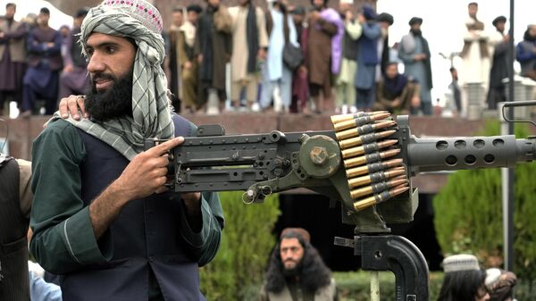 A Taliban fighter mans his weapon during celebrations one year after the Taliban seized the Afghan capital, Kabul, in front of the U.S. Embassy in Kabul, Afghanistan, Monday, Aug. 15, 2022.  - Sputnik भारत