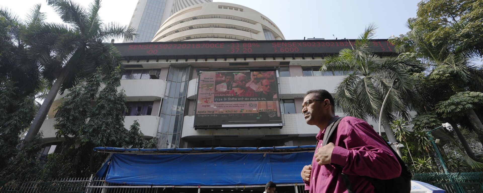 People walk past an electronic signage displaying news on federal budget at the Bombay Stock Exchange (BSE) building in Mumbai, India, Wednesday, Feb. 1, 2023. - Sputnik भारत, 1920, 10.06.2024