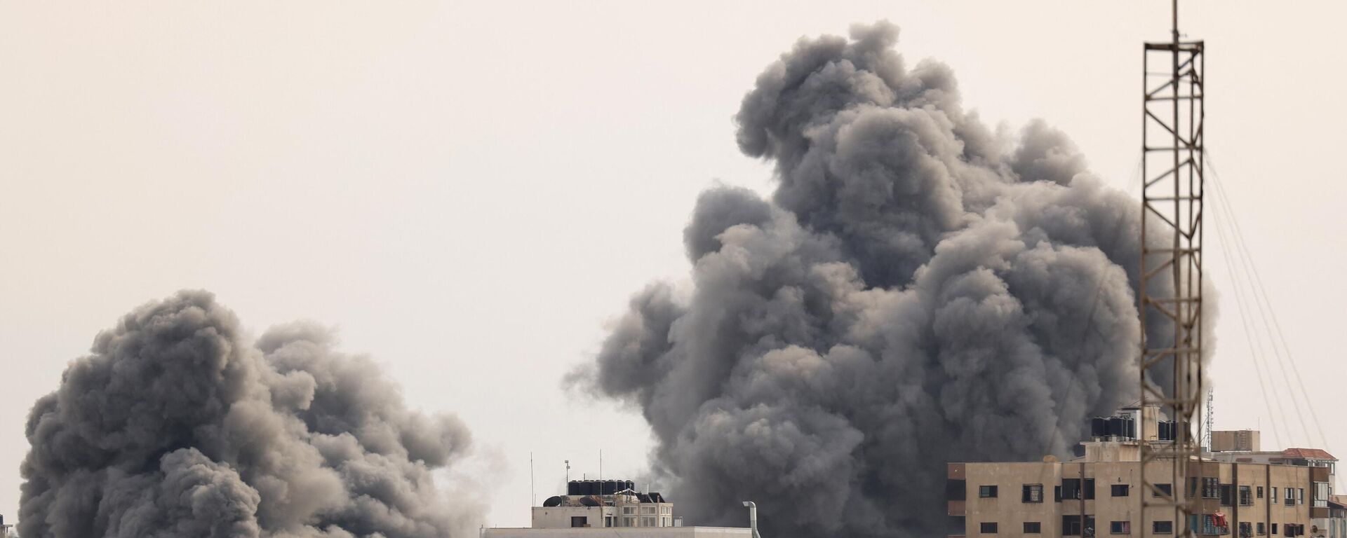 A black plume of smoke billows behind highrise buildings in the sky during an Israeli airstrike on Gaza City on October 9, 2023.  - Sputnik India, 1920, 10.10.2023