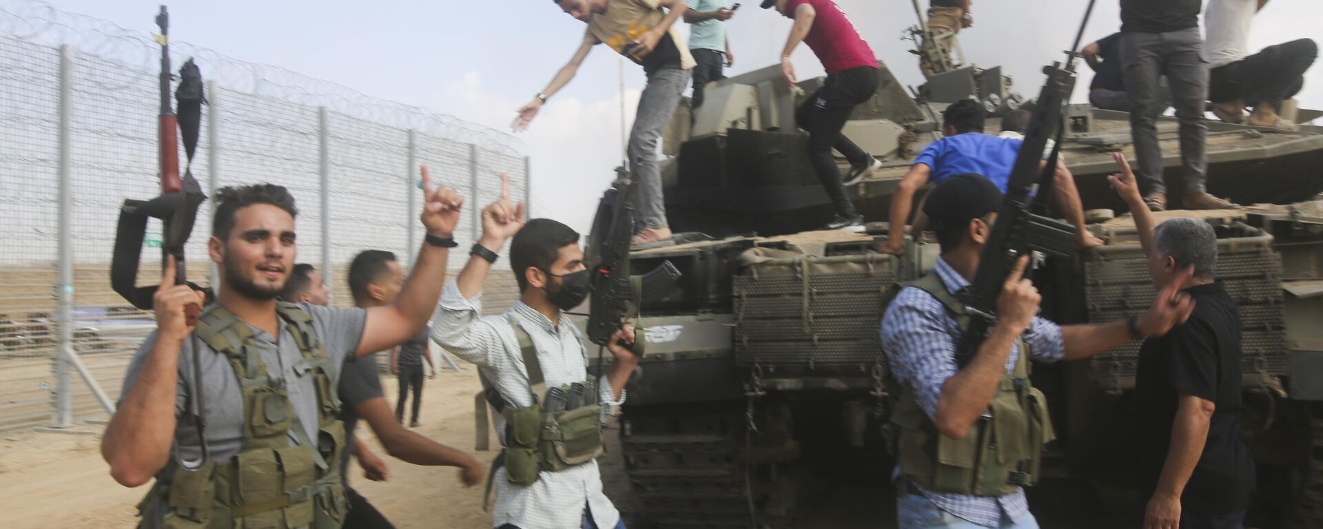 Palestinian militants celebrate by an Israeli tank at the border fence of the Gaza Strip - Sputnik भारत, 1920, 12.10.2023