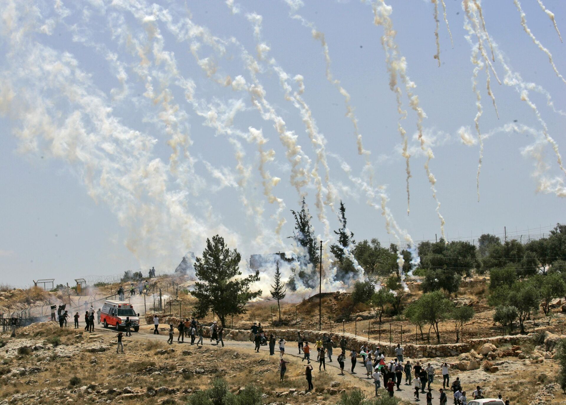 Palestinian, Israeli, and foreign demonstrators run from tear gas fired by Israeli troops during a demonstration against Israel's separation barrier in the West Bank village Bilin, near Ramallah, Friday, July 3, 2009 - Sputnik India, 1920, 13.10.2023