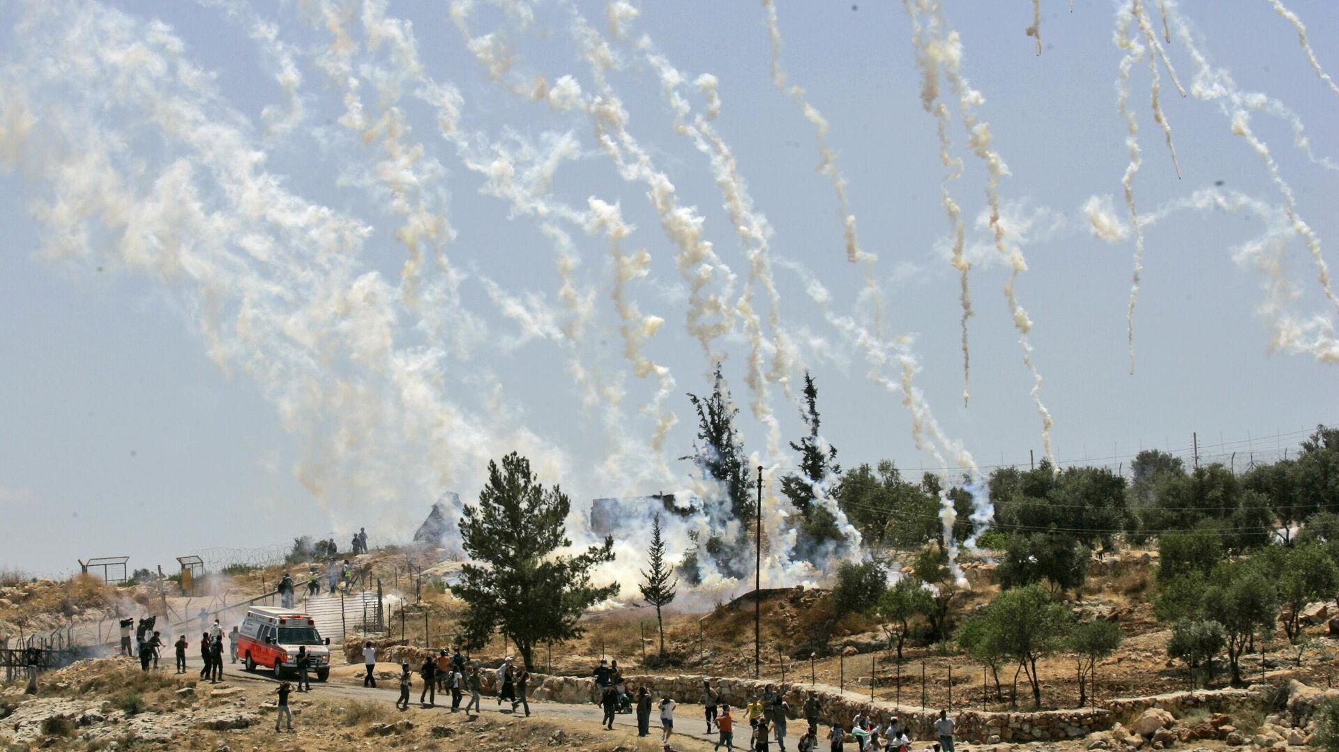 Palestinian, Israeli, and foreign demonstrators run from tear gas fired by Israeli troops during a demonstration against Israel's separation barrier in the West Bank village Bilin, near Ramallah, Friday, July 3, 2009 - Sputnik भारत, 1920, 13.10.2023
