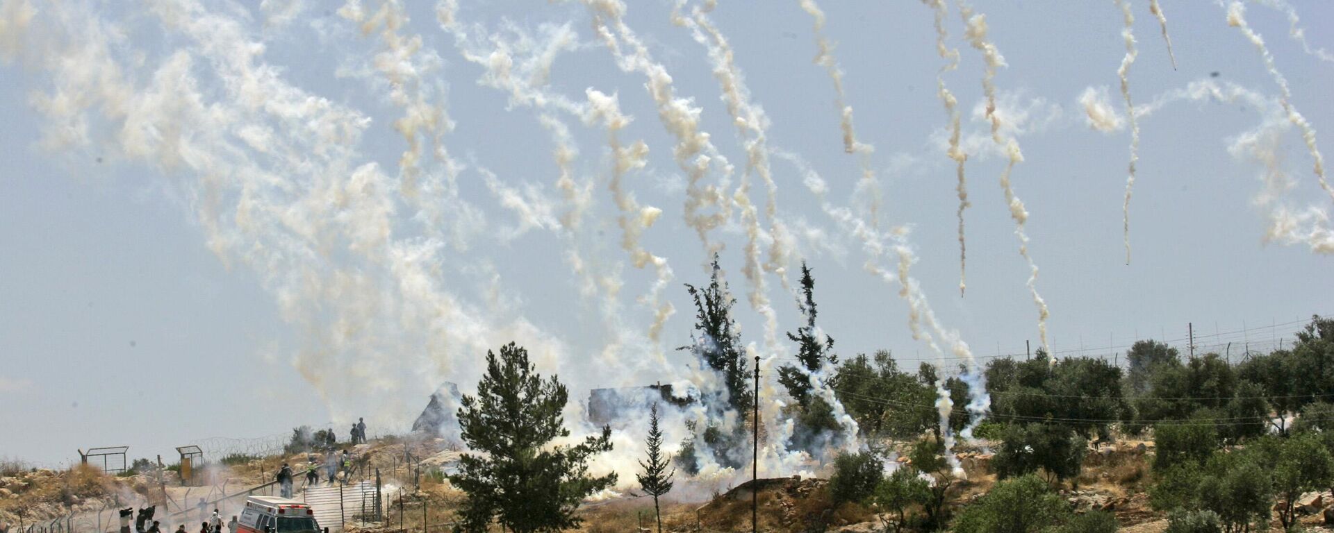 Palestinian, Israeli, and foreign demonstrators run from tear gas fired by Israeli troops during a demonstration against Israel's separation barrier in the West Bank village Bilin, near Ramallah, Friday, July 3, 2009 - Sputnik भारत, 1920, 13.10.2023