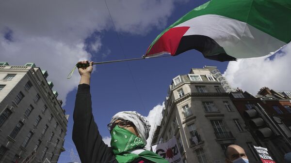 A man waves a Palestinian flag during a pro Palestinian demonstration in London, Saturday, Oct. 14, 2023, in support of Palestinians caught up in the war between Israel and Hamas. - Sputnik India