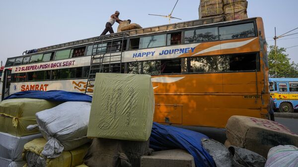Indian laborers loads sacks atop a long distance bus on May Day in Kolkata, India, Sunday, May 1, 2022. - Sputnik India