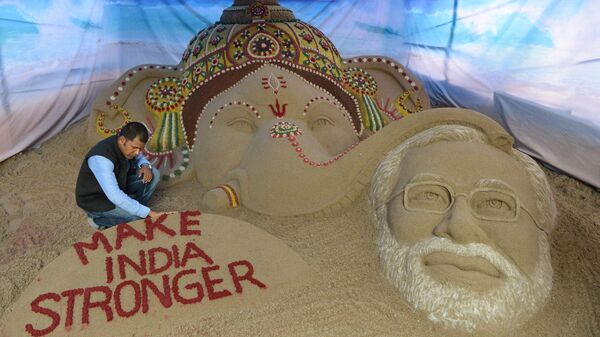 Indian sand artist Sudarsan Pattnaik makes finishing touches of a commissioned sand sculpture of Hindu god Lord Ganesha blessing Indian Prime Minister Narendra Modi at a Ganesh Pandal in Surat, some 265 kms from Ahmedabad, on August 28, 2014. - Sputnik India